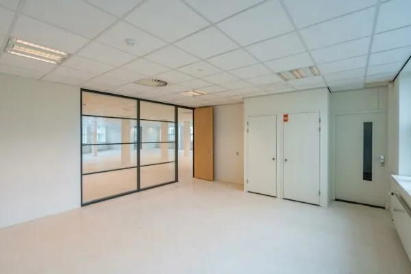 Licht en modern kantoorinterieur aan het Rhijnspoor met glazen tussenwand en witte deuren.
