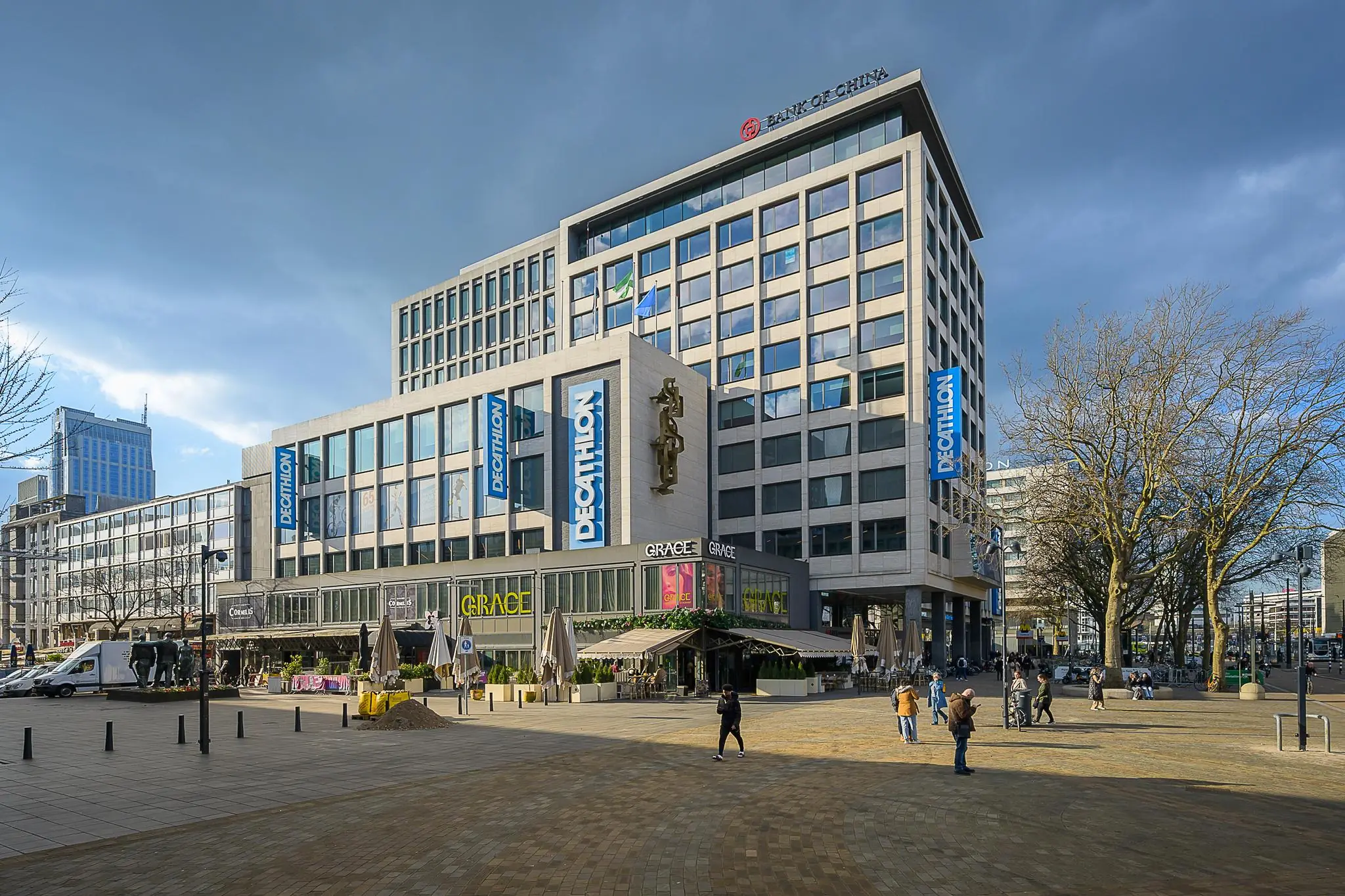 Straatbeeld van de Coolsingel in Rotterdam met het moderne gebouw van Decathlon en de Bank of China op de voorgrond.