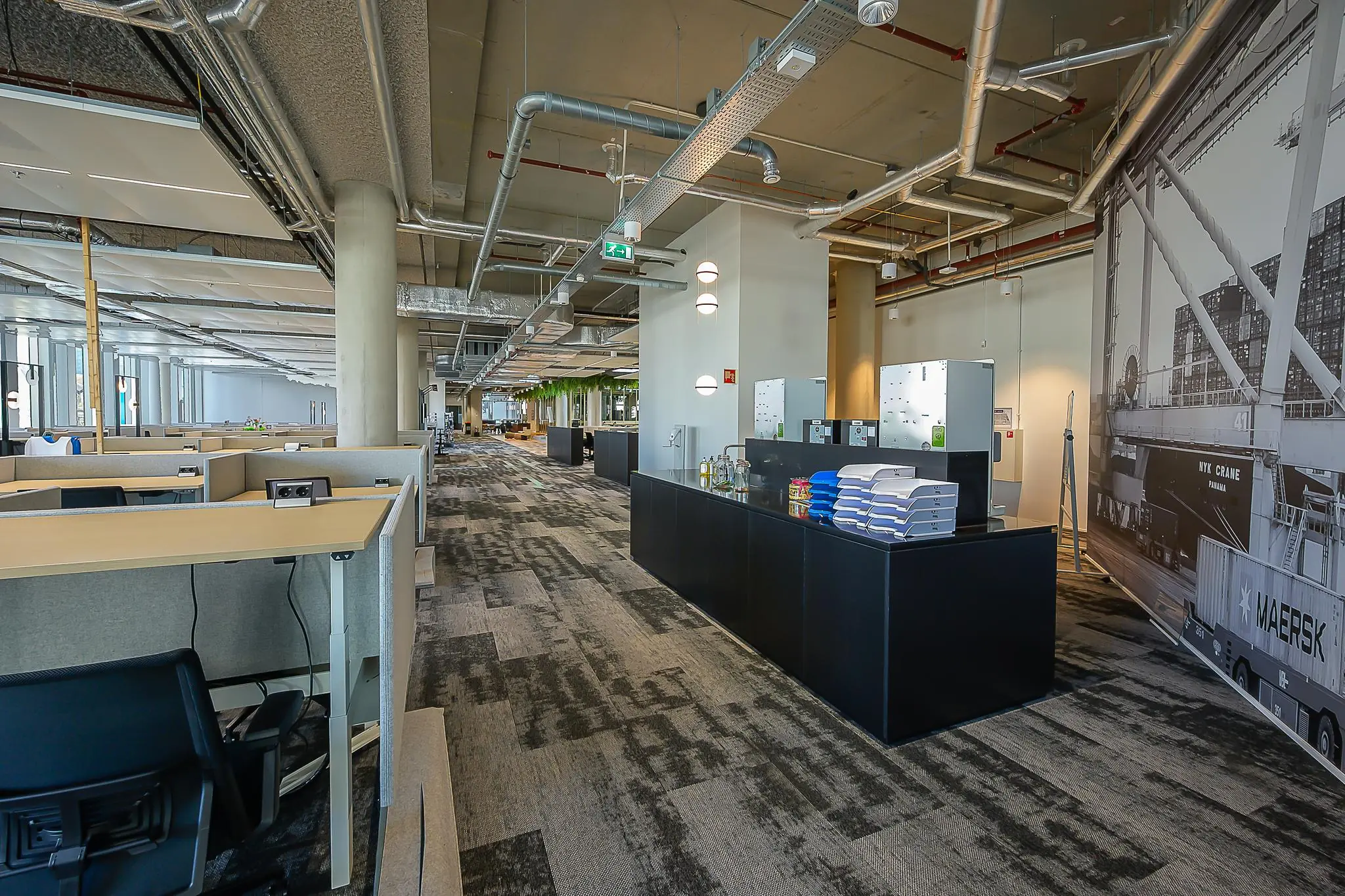 Moderne open kantoorruimte aan de Coolsingel met werkplekken, opbergkasten en een grote zwart-wit muurfoto van een containerterminal.
