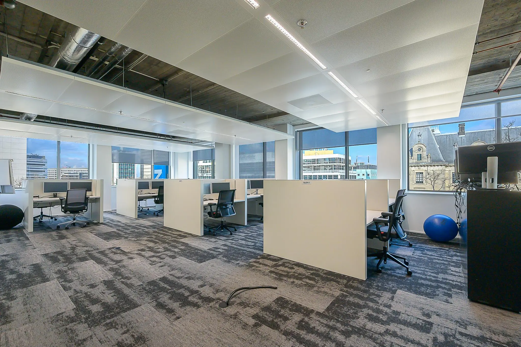 Modern kantoorinterieur aan de Coolsingel met werkplekken, bureaustoelen en uitzicht op Rotterdamse gebouwen.