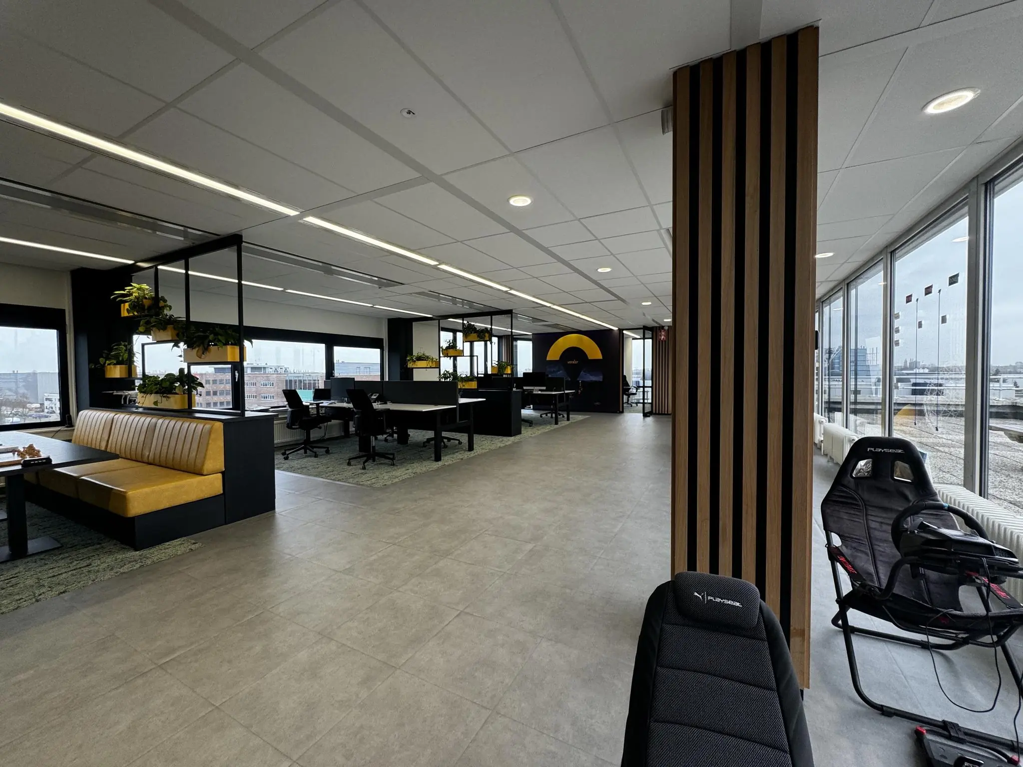 Moderne en open kantoorruimte in Rijnzathe met werkplekken, zithoeken, veel natuurlijk licht en een racesimulator.
