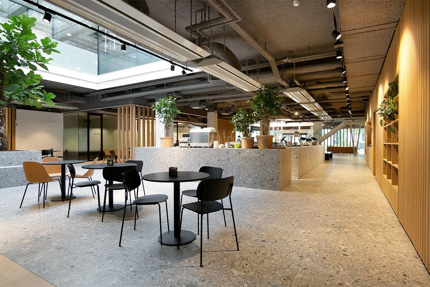 Moderne en open kantoorlounge in Rijnzathe met zitjes, planten en een koffiebar.