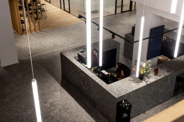 Receptiebalie van ND Rijnzathe met twee medewerkers in een modern kantoorinterieur.