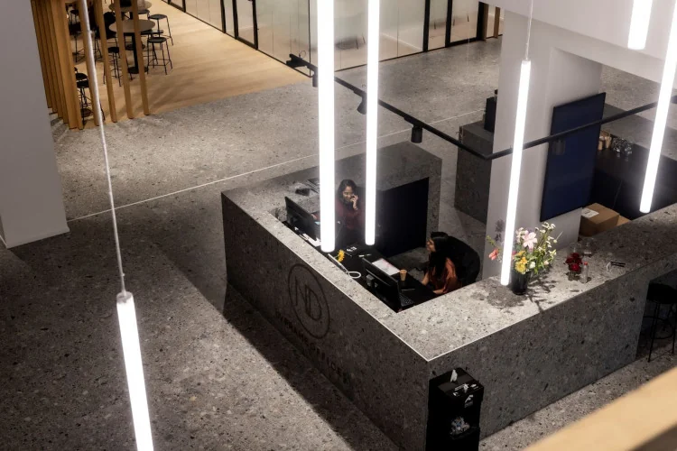 Receptiebalie van ND Rijnzathe met twee medewerkers in een modern kantoorinterieur.