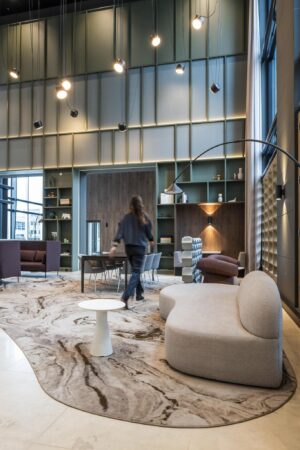Moderne en sfeervolle lobbyruimte in Amstelplein met designmeubels, hoge plafonds en warme verlichting.
