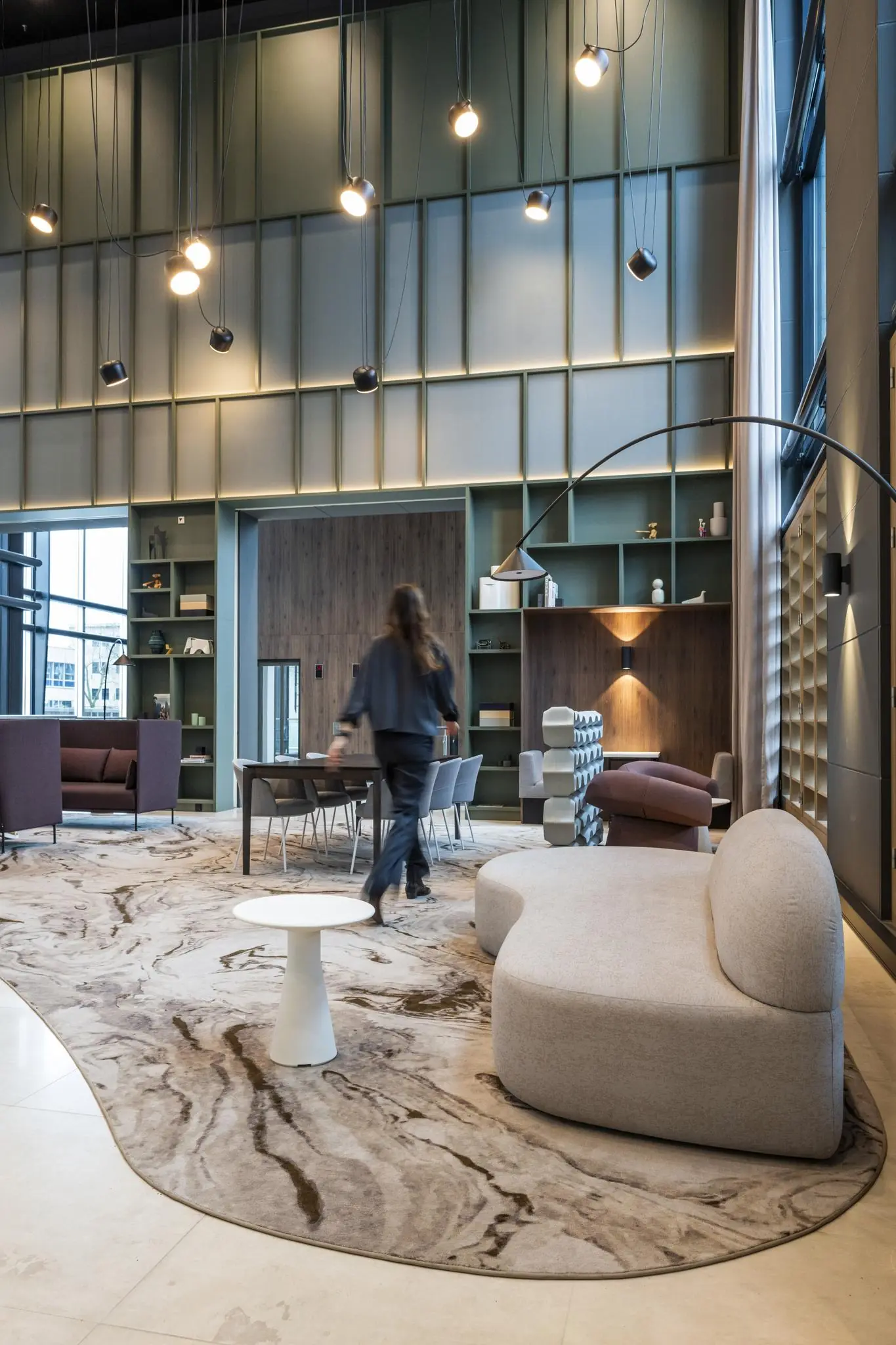 Moderne en sfeervolle lobbyruimte in Amstelplein met designmeubels, hoge plafonds en warme verlichting.