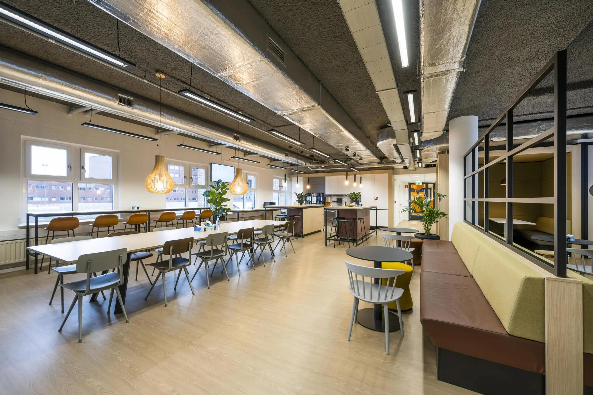 Moderne en sfeervolle kantoorkantine aan het Stationsplein met zitgelegenheden, planten en een open keuken.