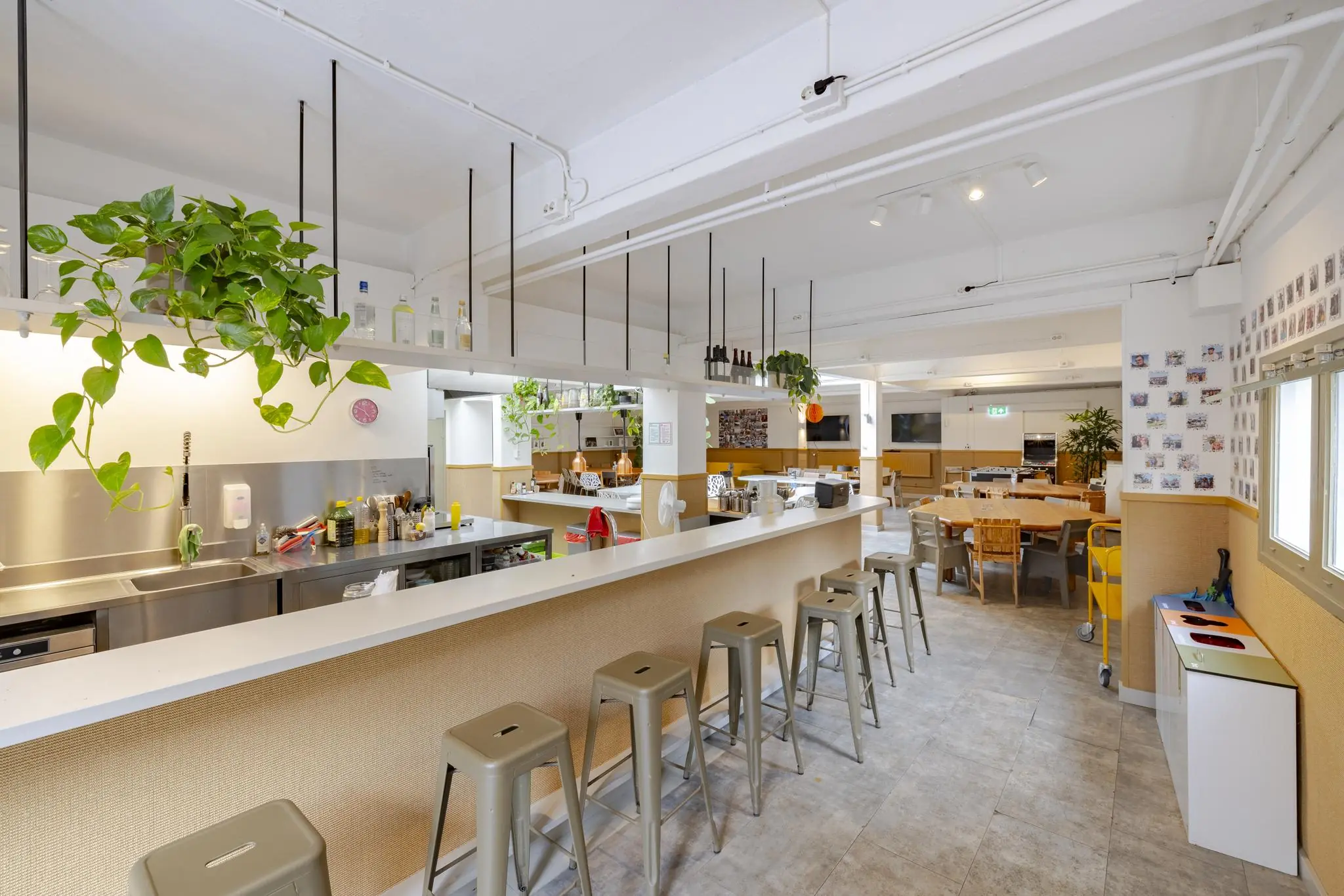 Moderne, open keuken met bar en zitgedeelte aan de Plantage Middenlaan, ingericht met planten en kleurrijke details.