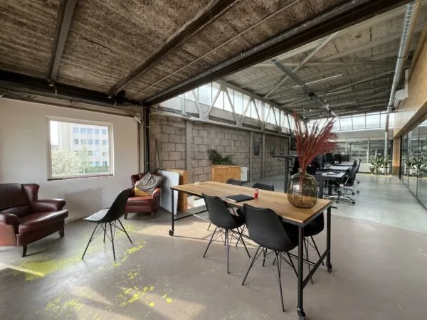 Industrieel ingerichte kantoorruimte aan de Eendrachtlaan met glazen wanden, betonnen muren en moderne werkplekken.