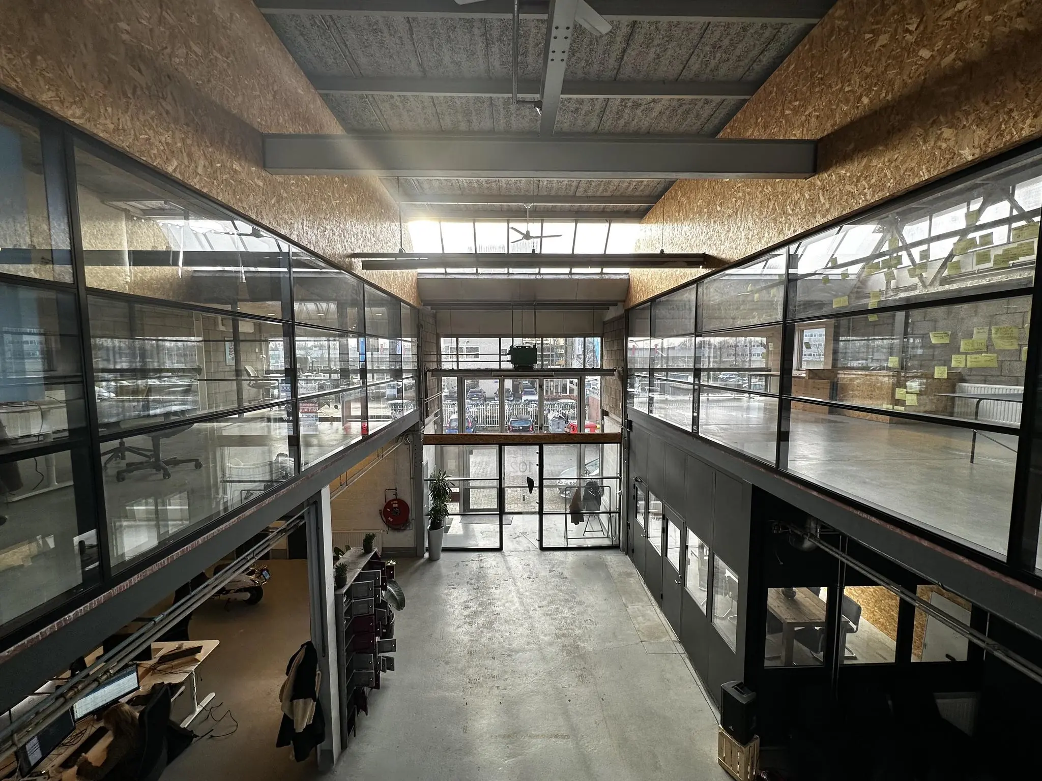 Modern bedrijfsinterieur aan de Eendrachtlaan met glazen kantoorruimtes op een entresol en een industriële uitstraling.