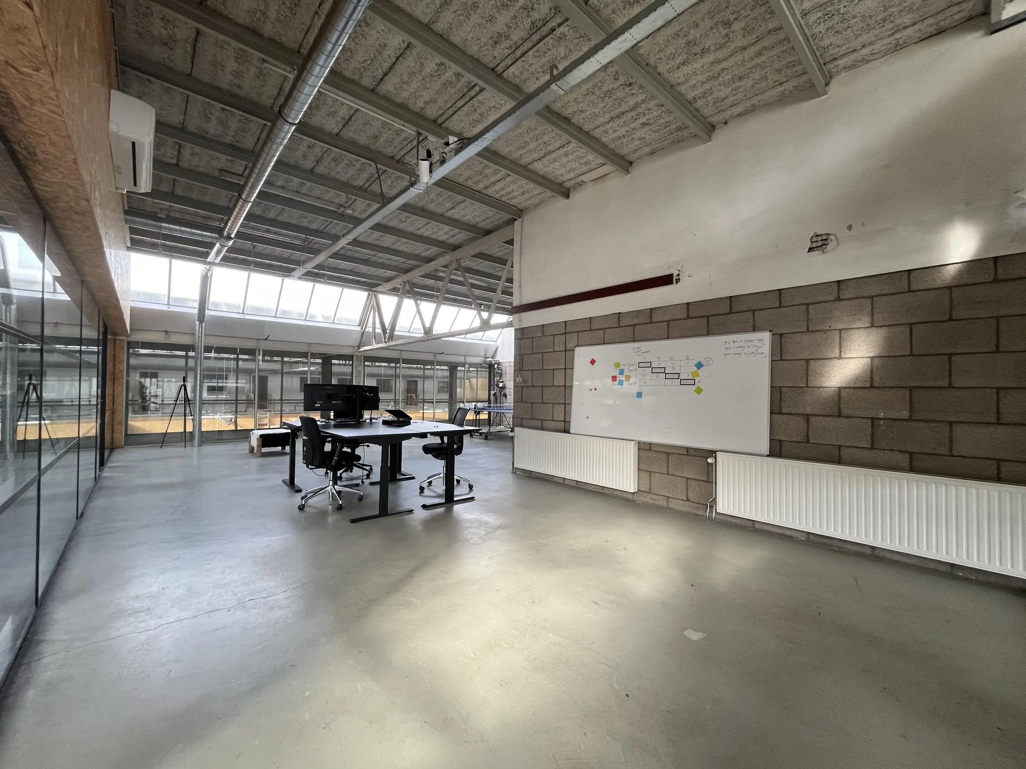 Ruime en lichte kantoorruimte aan de Eendrachtlaan met een vergadertafel, glazen wanden en een whiteboard aan de muur.