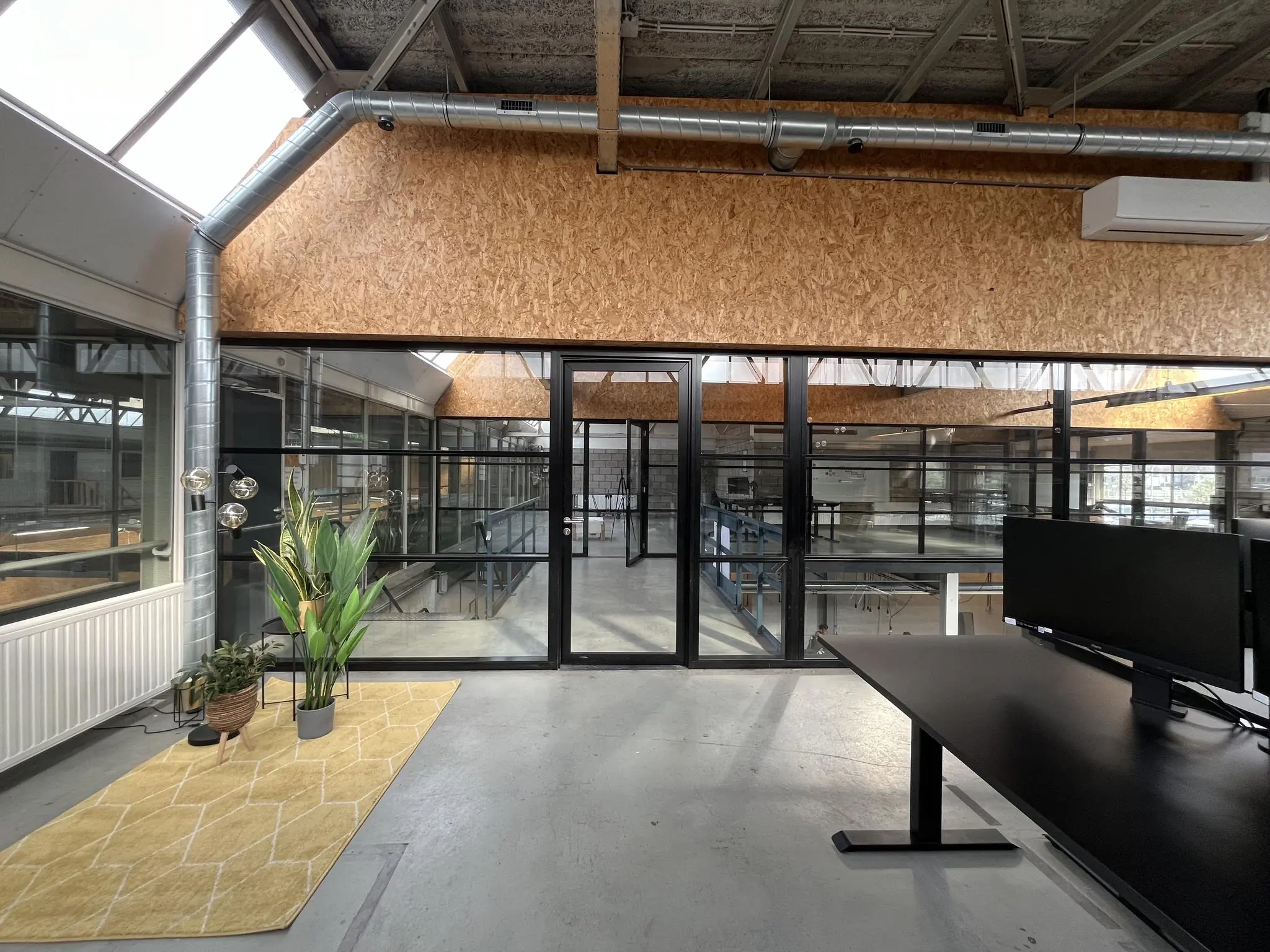 Modern kantoorinterieur aan de Eendrachtlaan met glazen wanden, houten accenten en industriële details.