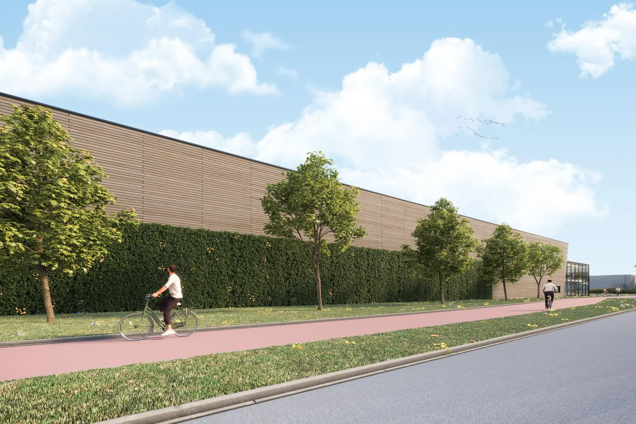 Fietsers rijden over het fietspad langs een modern bedrijfspand aan de Nijverheidsweg met groene gevel en bomen.