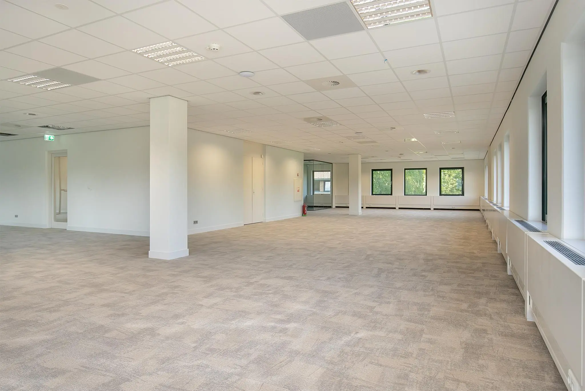 Ruime, lege kantoorruimte aan de Kralingseweg met grote ramen en systeemplafond.