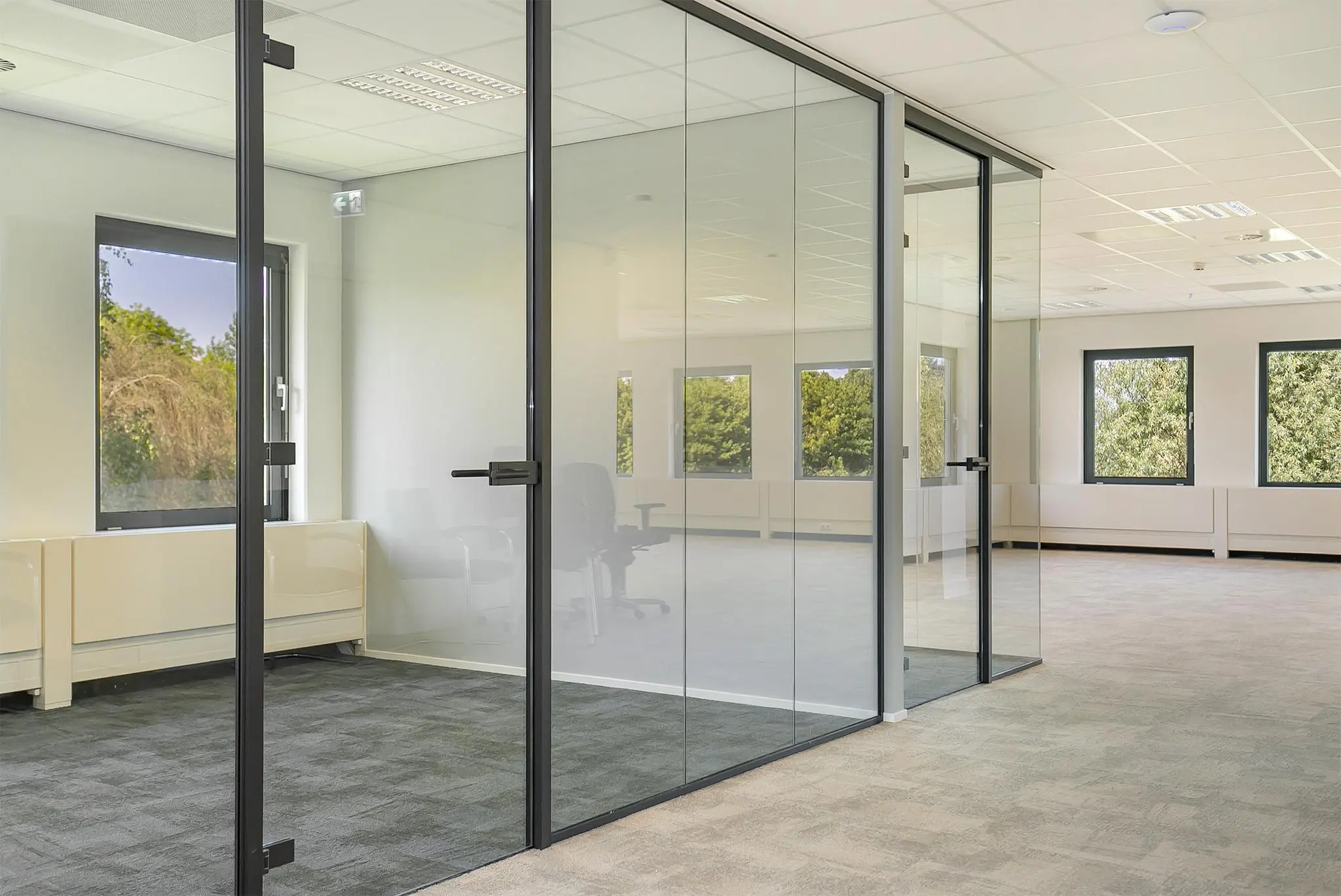 Moderne, lichte kantoorruimte aan de Kralingseweg met glazen wanden en uitzicht op groen.