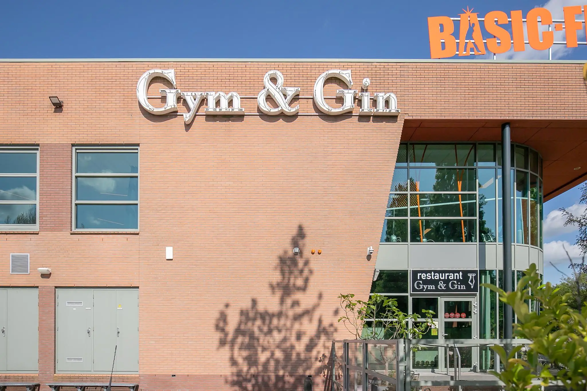 Vooraanzicht van het gebouw aan de Kralingseweg met het restaurant Gym & Gin en sportschool Basic-Fit.