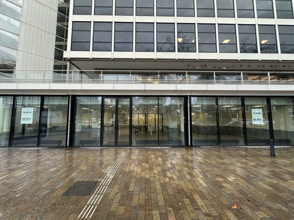 Vooraanzicht van een leegstaand kantoorpand aan de Coolsingel in Rotterdam met 'Te Huur' posters op de ramen.
