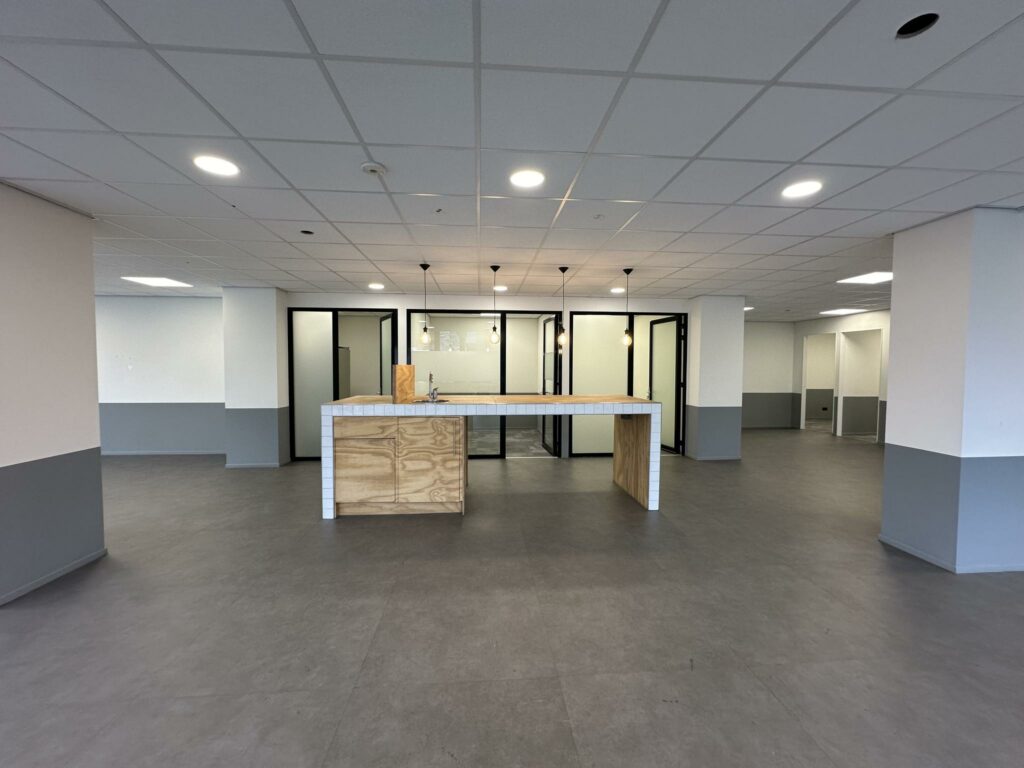 Moderne, lege kantoorruimte aan de Coolsingel met open kitchenette en glazen vergaderruimtes.