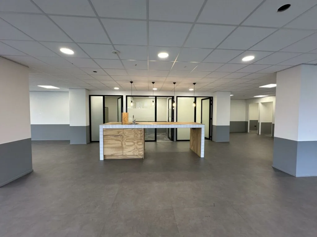 Moderne, lege kantoorruimte aan de Coolsingel met open kitchenette en glazen vergaderruimtes.