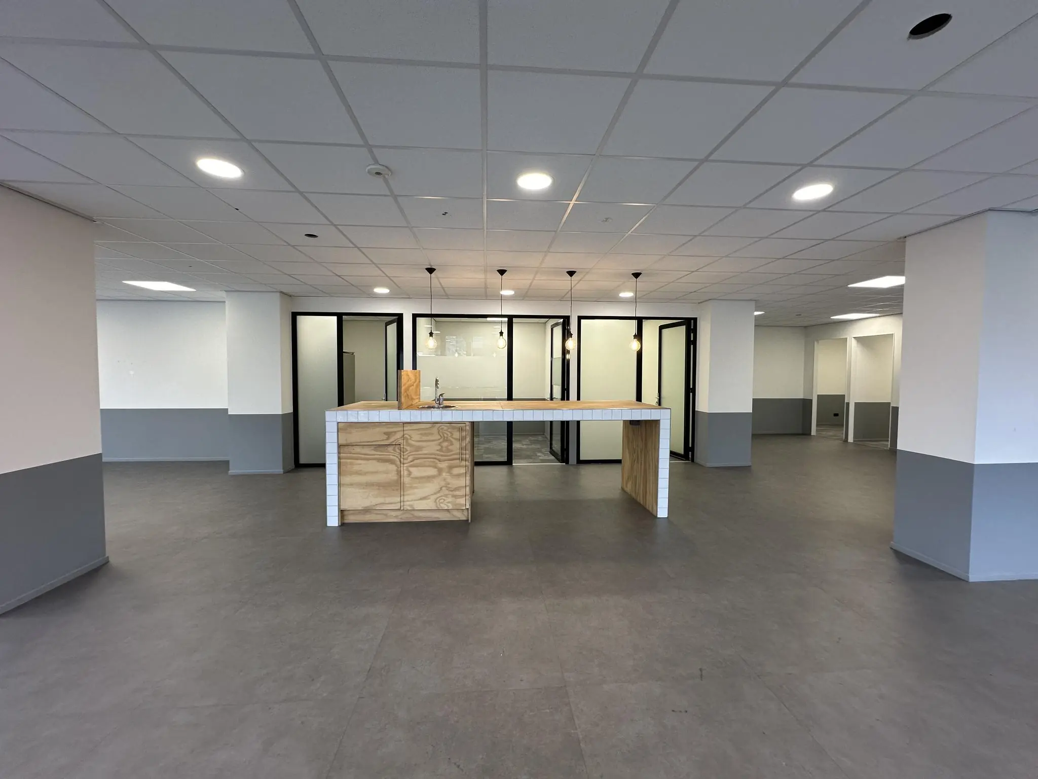 Moderne, lege kantoorruimte aan de Coolsingel met open kitchenette en glazen vergaderruimtes.