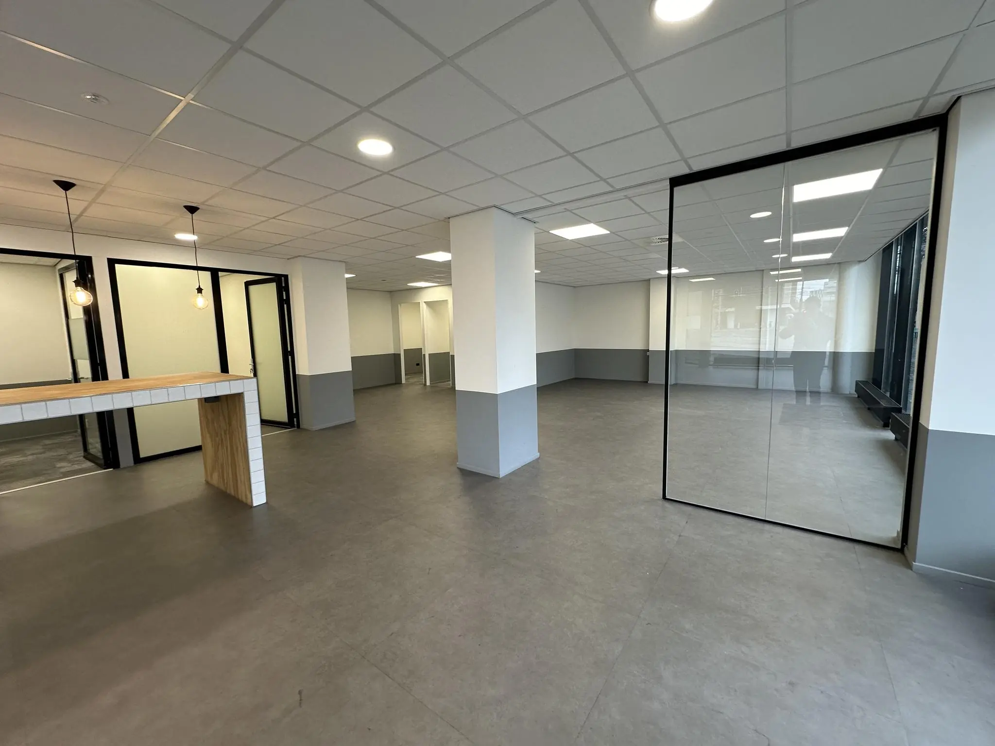 Moderne, lege kantoorruimte aan de Coolsingel met glazen wanden, systeemplafond en strakke afwerking.