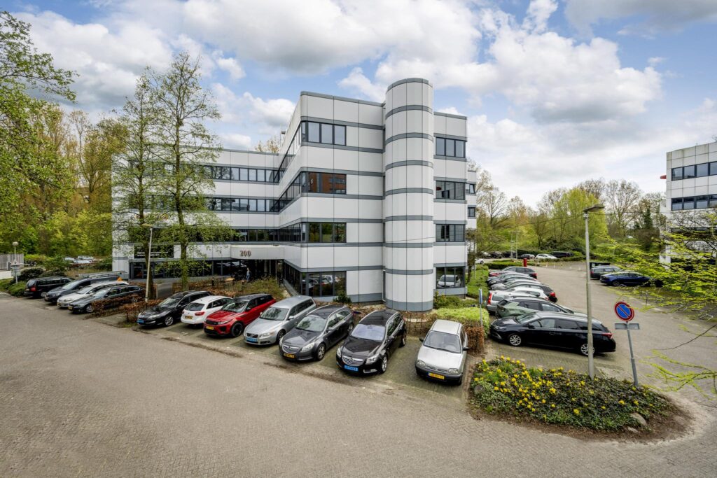 Modern kantoorgebouw aan de Entrada 309 met omliggende parkeerplaatsen en groene omgeving.