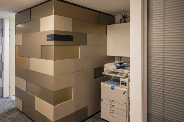 Kopieerruimte met een printer naast een modern betegelde muur in kantoorgebouw Middenburcht.