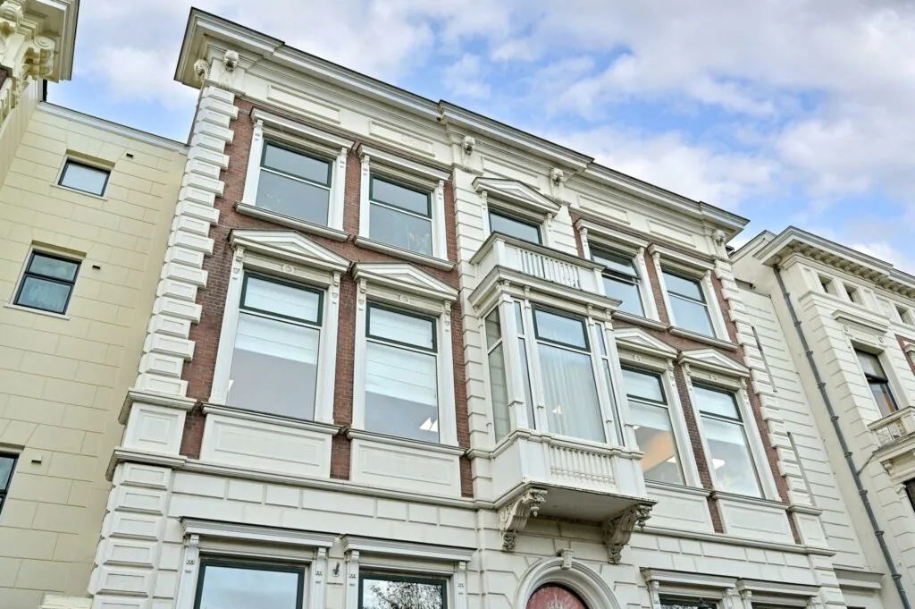 Voorgevel van een monumentaal pand aan de Koninginnegracht met klassieke architectuur en kenmerkende erker.