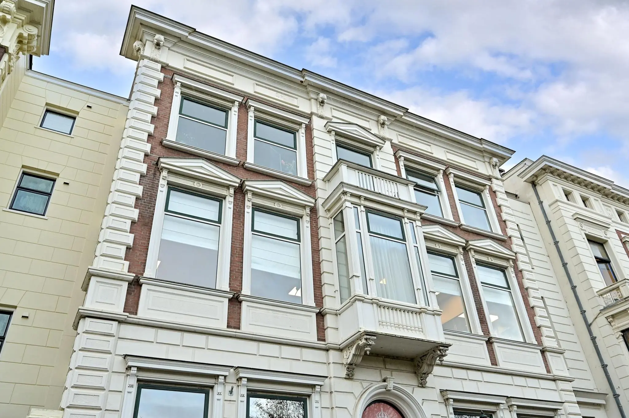 Voorgevel van een monumentaal pand aan de Koninginnegracht met klassieke architectuur en kenmerkende erker.