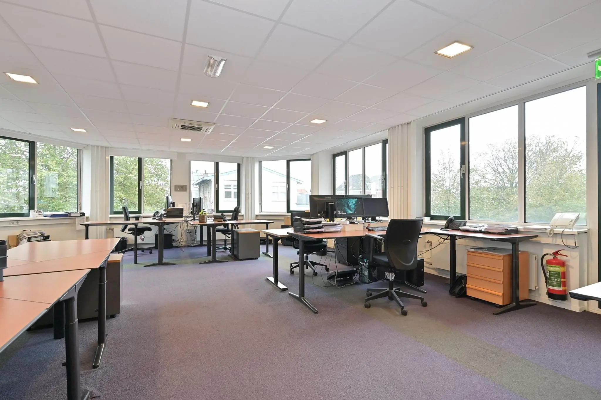 Ruim en licht kantoor aan de Koninginnegracht met meerdere werkplekken en grote ramen.