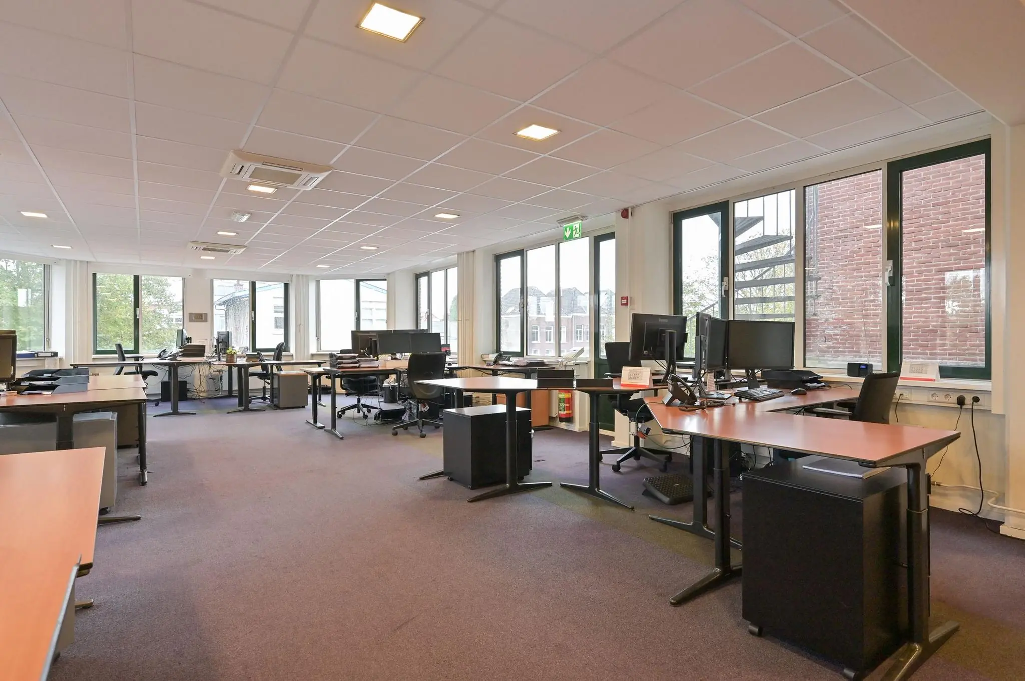 Ruim en licht kantoor aan de Koninginnegracht met meerdere werkplekken en grote ramen.