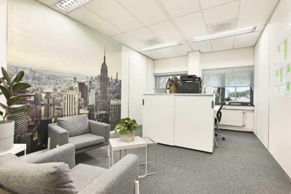 Modern kantoorinterieur aan de Winthontlaan met zithoek, bureauruimte en een wanddecoratie van de skyline van New York.