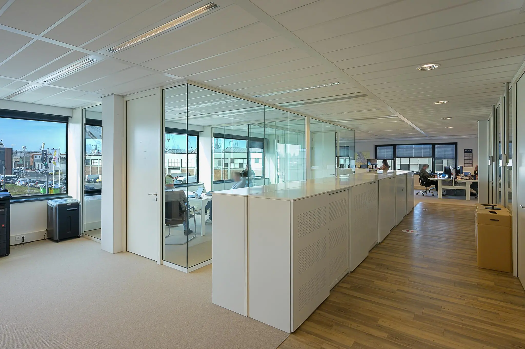 Modern ingericht kantoorpand aan de Willingestraat met glazen vergaderruimtes en werkplekken.