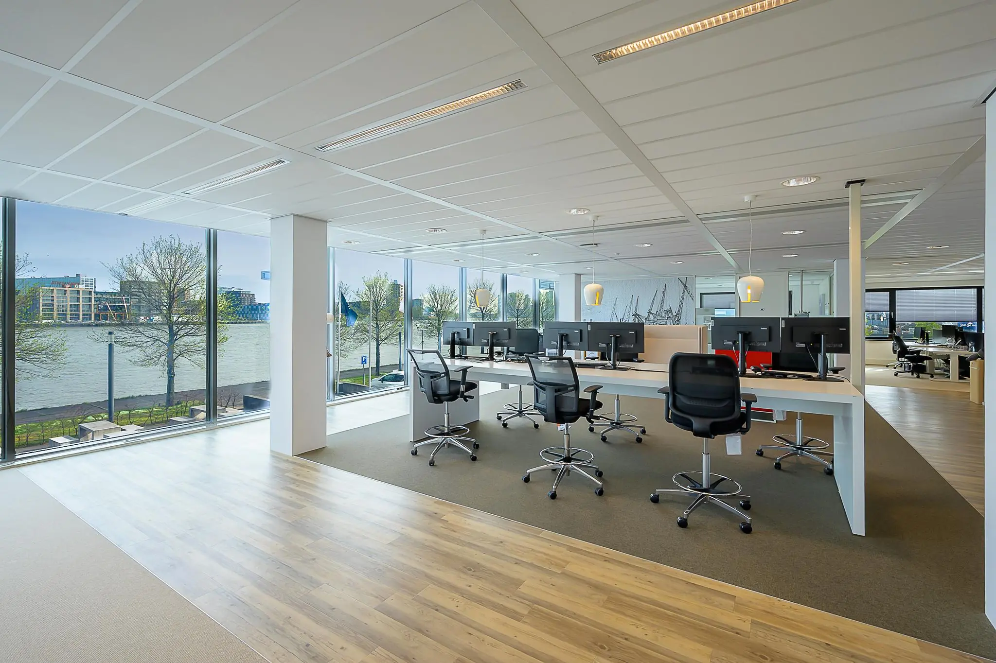 Modern kantoorinterieur aan de Willingestraat met werkplekken en uitzicht op het water.