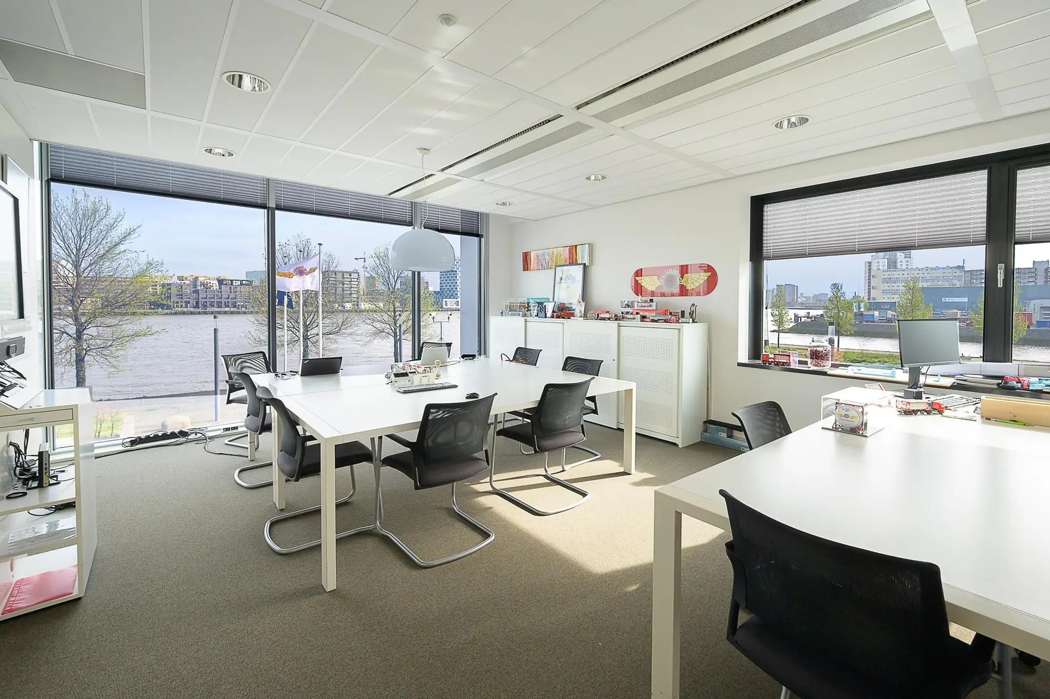 Modern ingericht kantoor aan de Willingestraat met uitzicht op het water en grote ramen die veel daglicht binnenlaten.