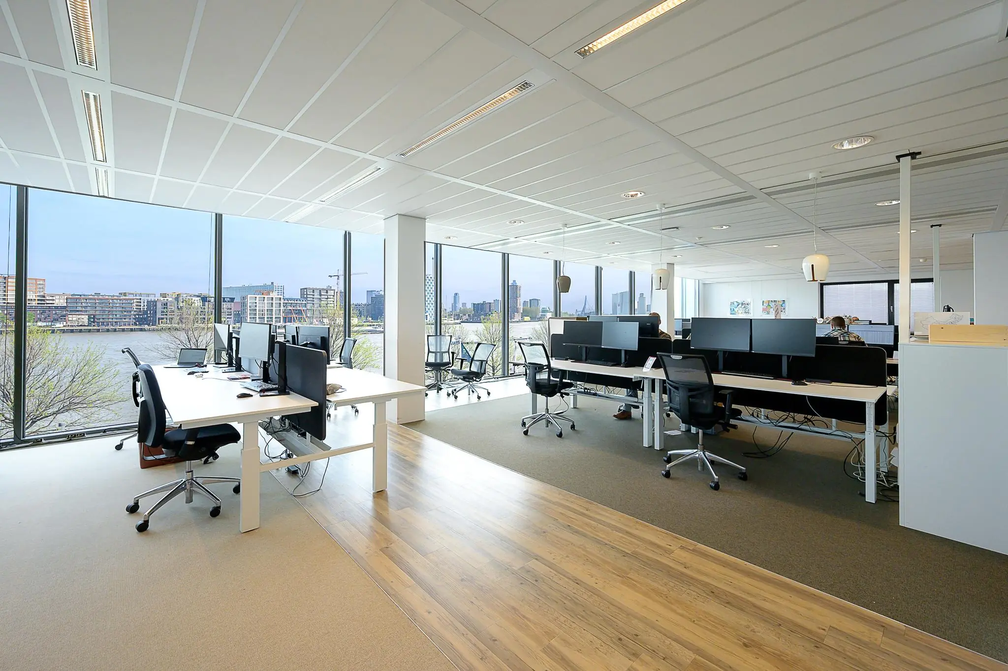 Modern kantoorinterieur aan de Willingestraat met werkplekken en uitzicht op het water en de stad.