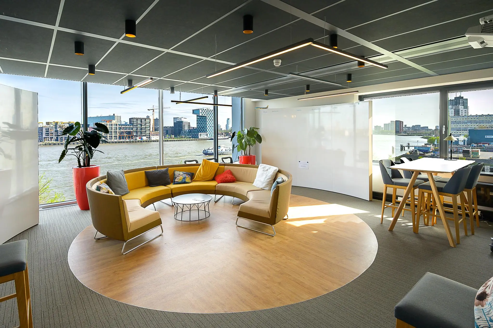 Moderne kantoorruimte met een ronde zithoek, uitzicht op het water en grote ramen aan de Willingestraat.