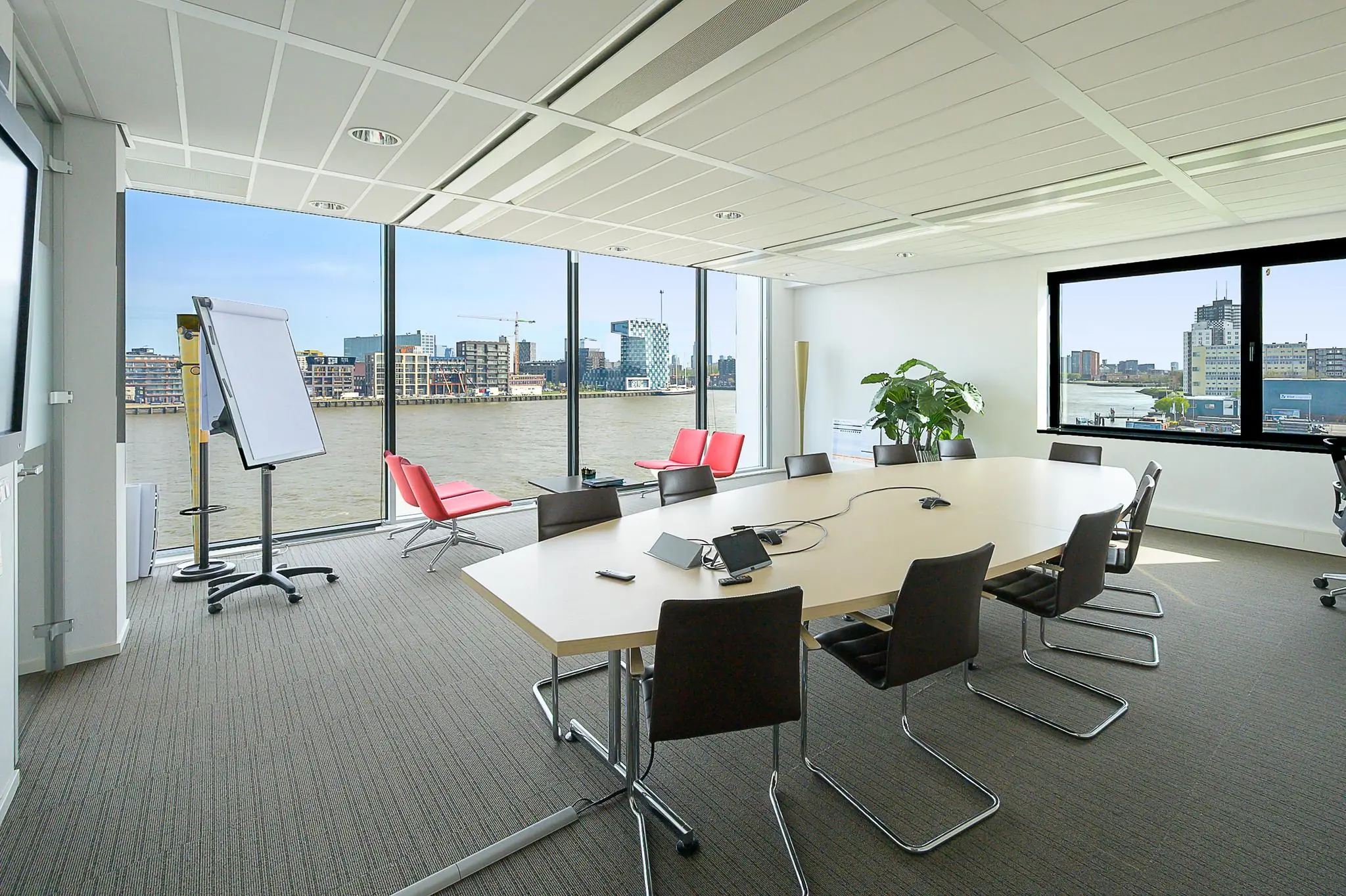 Moderne vergaderruimte aan de Willingestraat met uitzicht op het water en de skyline van de stad.