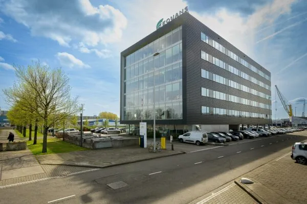 Modern kantoorgebouw van Geonavs aan de Willingestraat met parkeerplaatsen en bomen langs de straat.