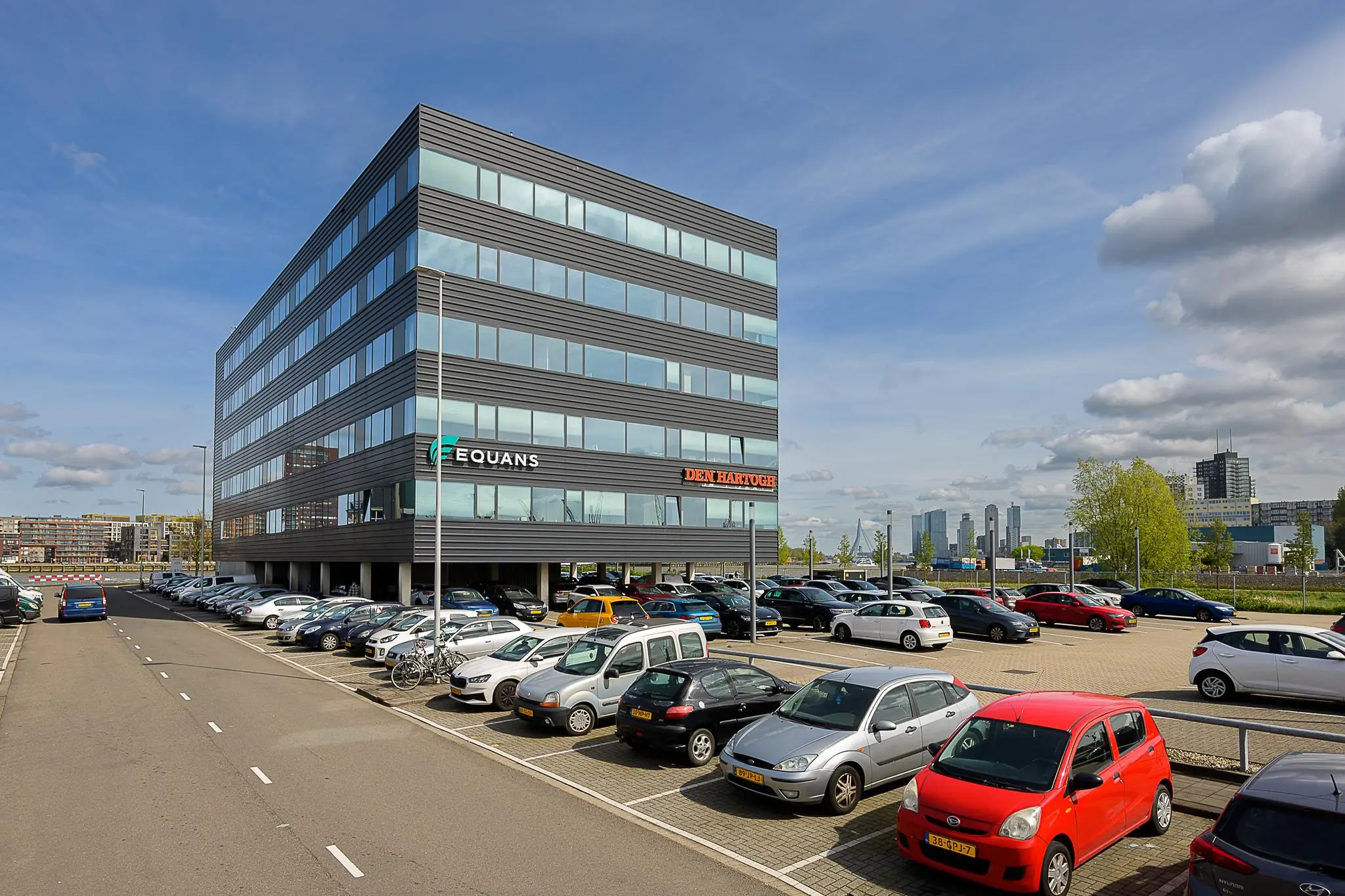 Kantoorgebouw aan de Willingestraat met parkeergarage en borden van Equans en Den Hartogh op de gevel.