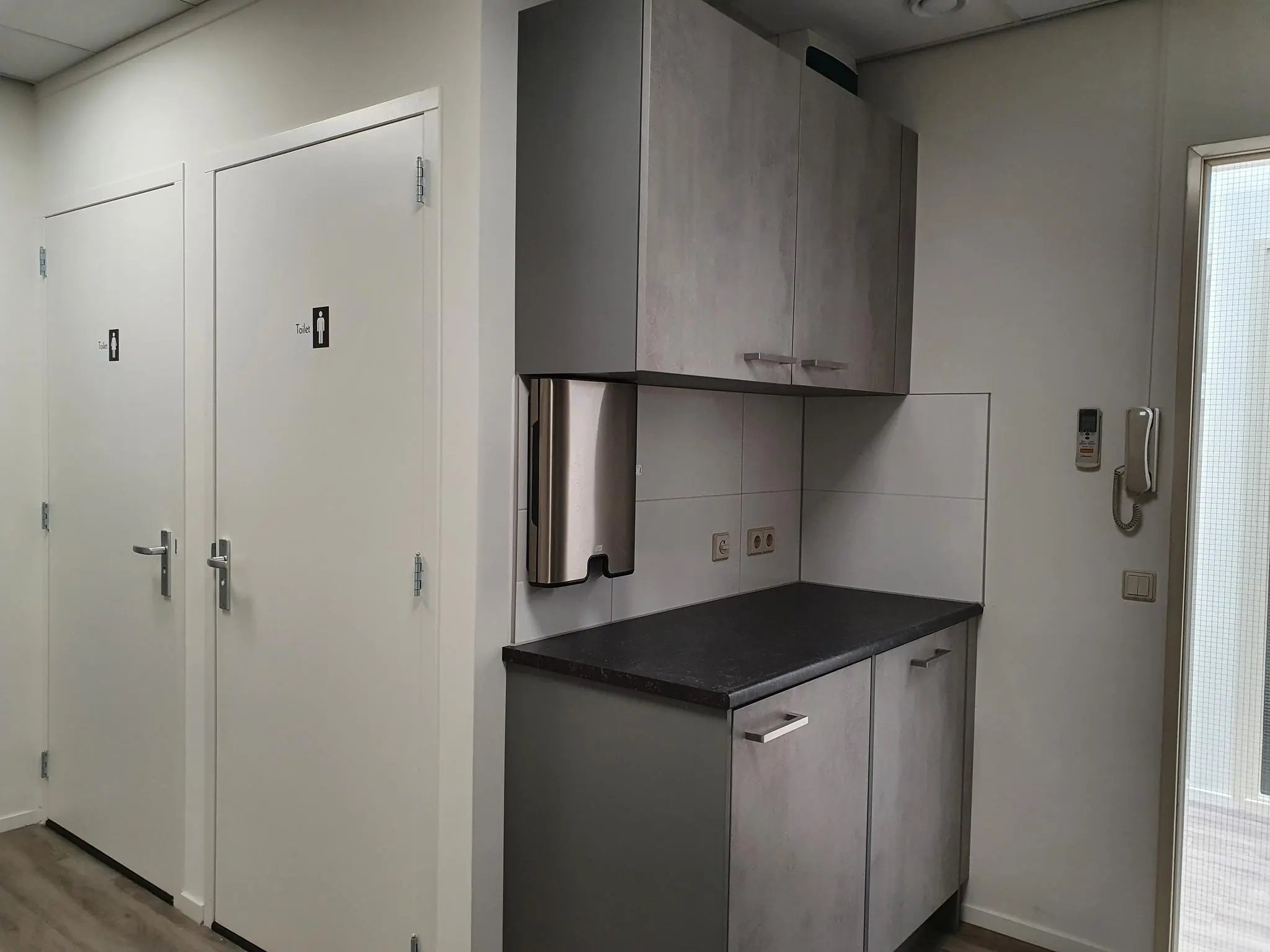 Keukenblok met bovenkastjes naast twee toiletdeuren in een nette, modern ingerichte ruimte in Bergveste.