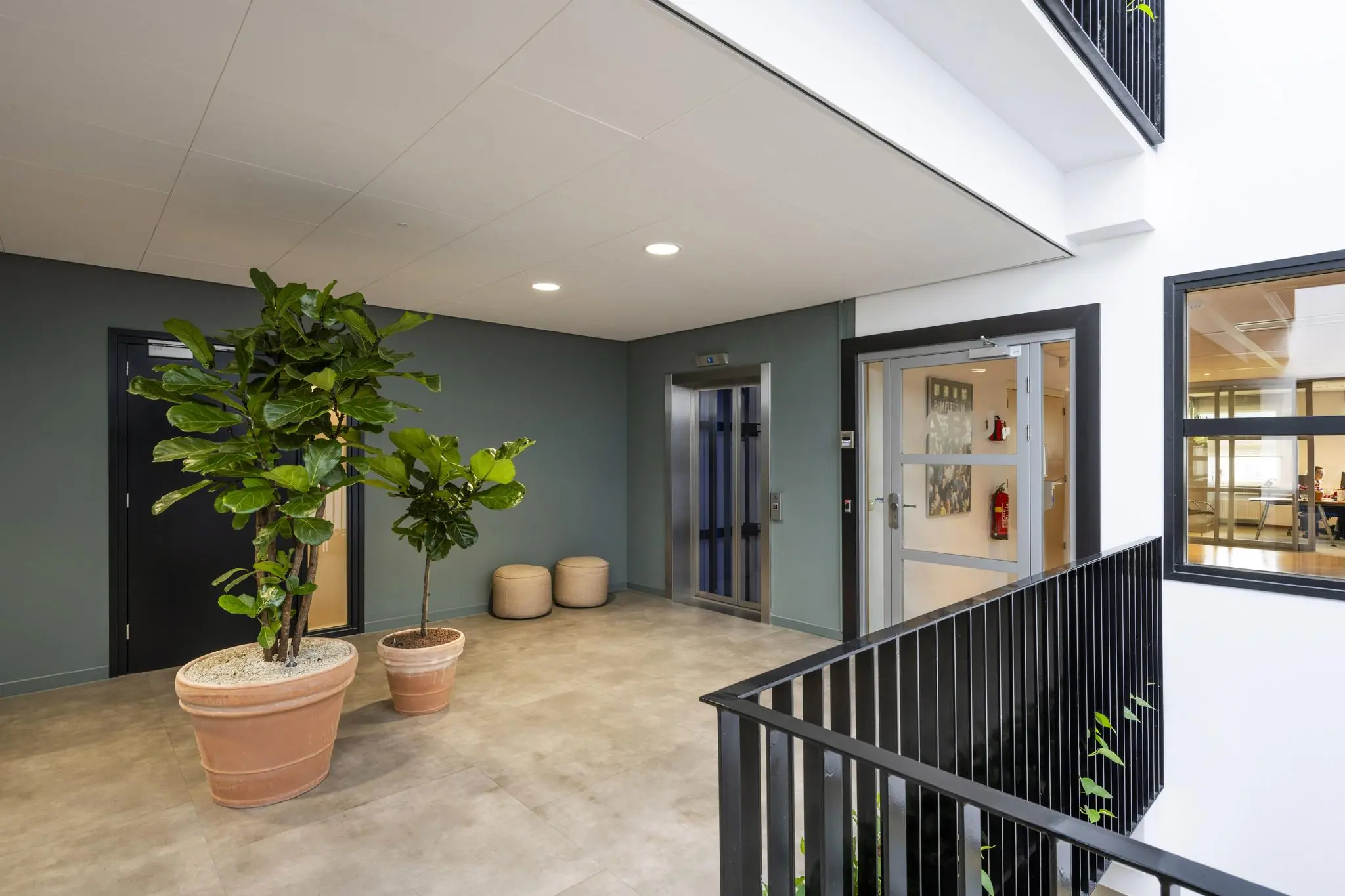 Moderne binnengalerij bij Singaporestraat met lift, planten en toegang tot appartementen.