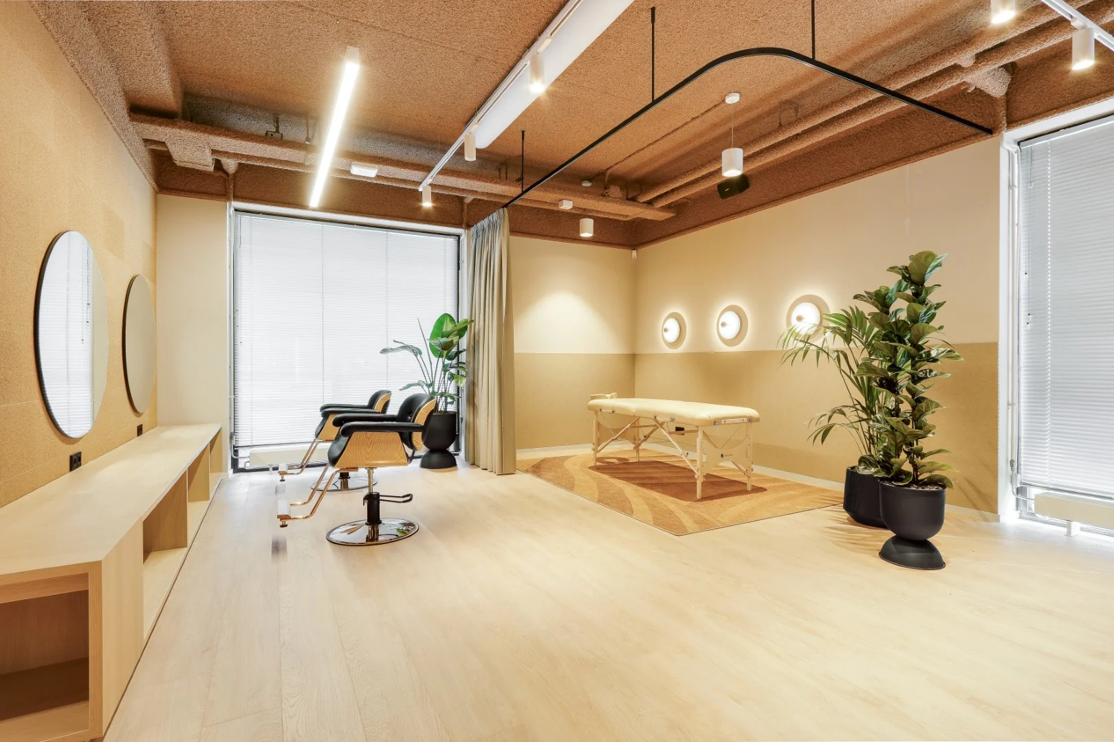 Wellnessruimte in Sloterdijk met een massagebank, twee stoelen en moderne inrichting.