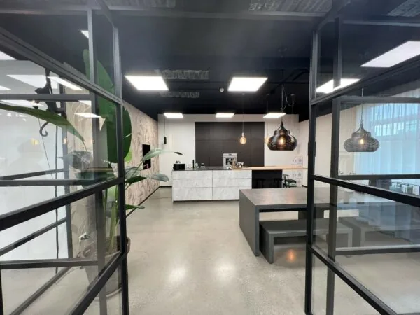 Moderne keukenruimte aan de Frankfurtstraat met stijlvolle verlichting, een marmeren kookeiland en een betonnen eettafel.