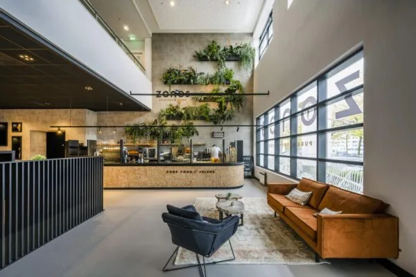 Modern ingerichte horecagelegenheid aan de Laarderhoogtweg met een groene plantenwand, zithoek en strakke interieurstijl.