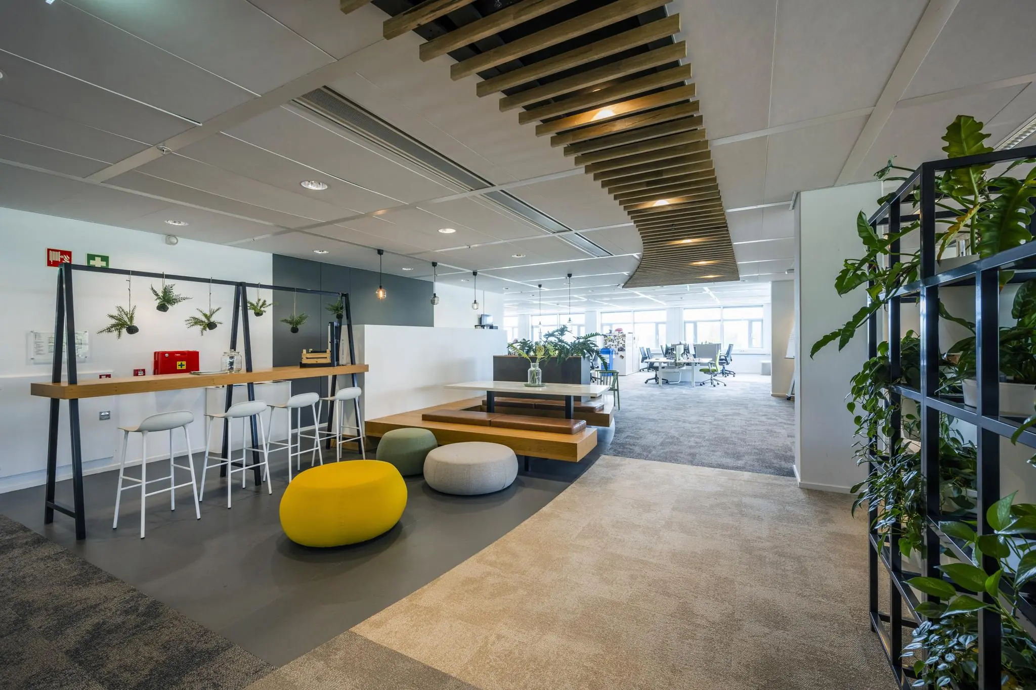 Modern en licht ingericht kantoor aan de Laarderhoogtweg met zitplekken, hangplanten en open werkruimtes.