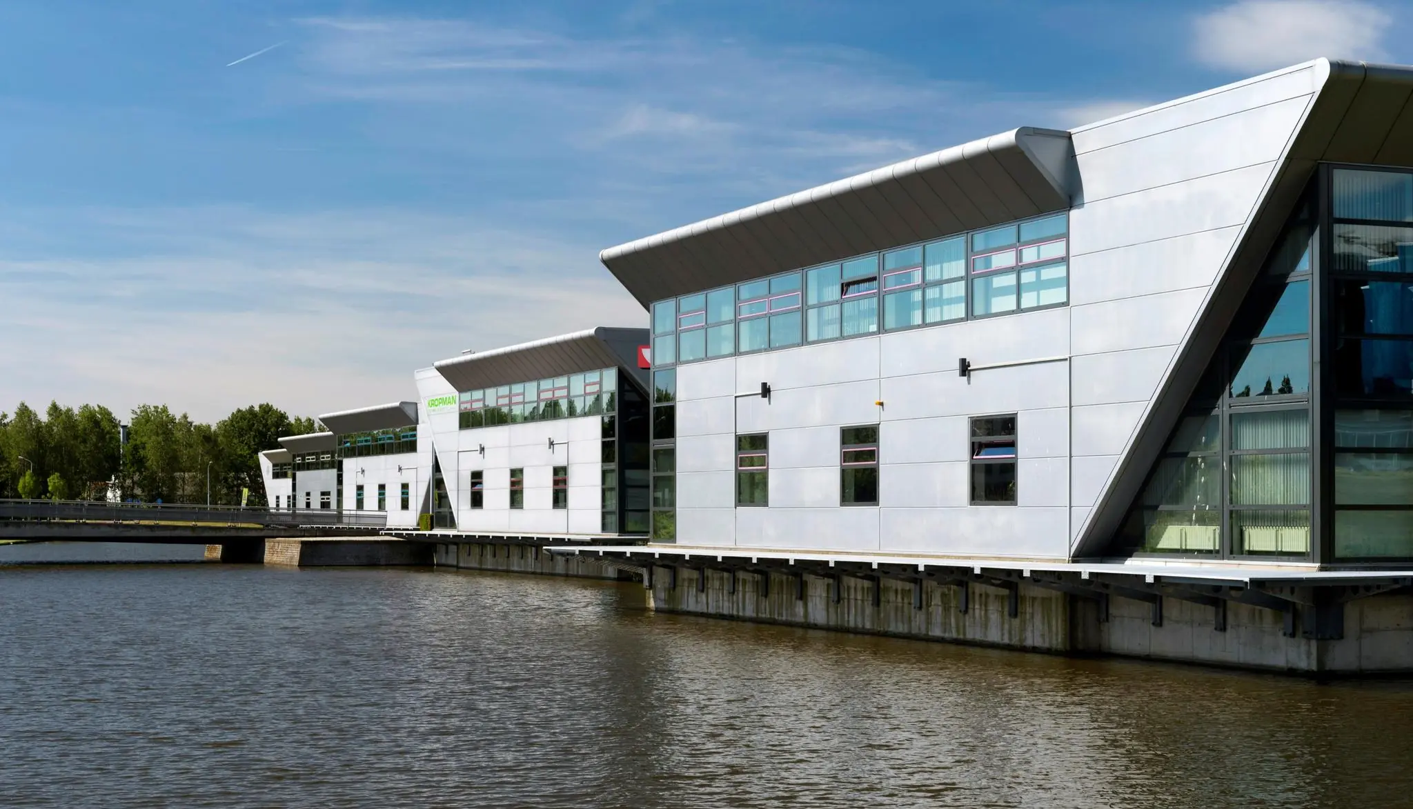 Moderne kantoorgebouwen aan het water aan de Frankfurtstraat in een groene omgeving.