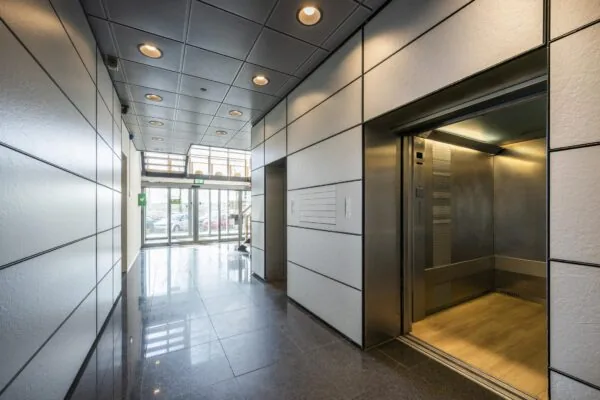 Moderne entreehal met openstaande lift in een kantoorgebouw aan de Joan Muyskenweg.