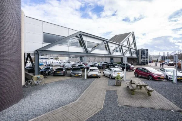 Parkeerterrein aan de Meidoornkade met een modern kantoorgebouw en diverse geparkeerde auto's.