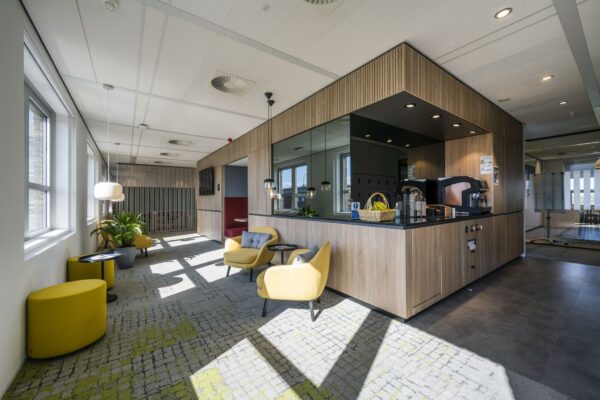 Moderne kantoorlounge aan de Orteliuslaan met zithoek, koffiecorner en veel natuurlijk licht.